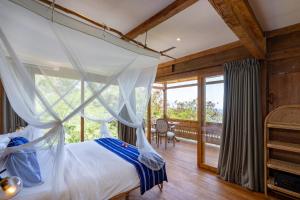 蓝梦岛Morin Resort的一间卧室设有一张天蓬床和一个阳台