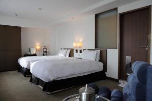 台北国联大饭店的酒店客房,设有两张床和一张沙发