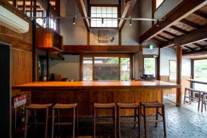 由布市伊诺吉亚日式旅馆的厨房设有酒吧,里面摆放着凳子