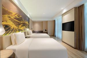 南宁南宁南湖地铁站亚朵酒店 的酒店客房设有两张床和电视。