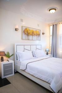 布拉柴维尔residence queen house的卧室设有一张白色大床和一扇窗户。