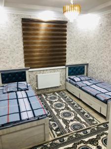 希瓦Ancient Khiva appartment 2的配有地毯的客房内的两张床