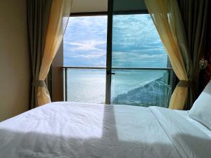 乔木提恩海滩Copacabana Jomtien Beach Condo 中天海滩寇芭酒店公寓的一张位于带大窗户的房间内的床铺