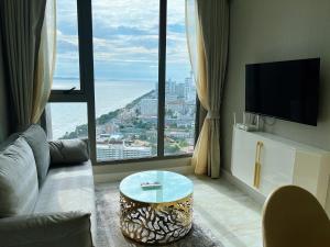 乔木提恩海滩Copacabana Jomtien Beach Condo 中天海滩寇芭酒店公寓的客厅配有沙发和窗户前的桌子