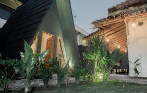 TimuranRanasa Yogyakarta的前面有植物的绿色房子