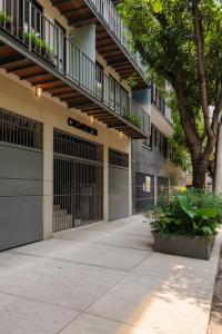 墨西哥城Choapan 28 - Lux Apartments in Condesa的一座建筑,有两扇车库门和一棵树