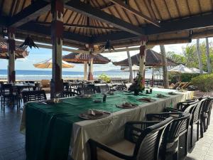 甘地达萨Pondok Bambu Resort - 5 Stars Padi Dive Centre的海滩餐厅内的长桌