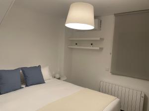马德里C1 Madrid, Zona exclusiva的一间卧室配有一张带蓝色枕头和灯的床