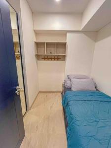 棉兰Brand new 2BR Empire Tower - Podomoro City的小房间设有一张床和一个衣柜