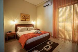 卡拉马塔Hotel Panorama的一间卧室配有一张带橙色毯子和窗户的床。