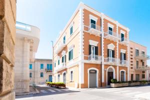 莫诺波利Casa Del Barone - Luxury Suites的一条白色的街道上白色的橙色大建筑