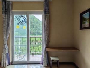 恩施Valley Oasis Villa的客房设有阳台景窗户。