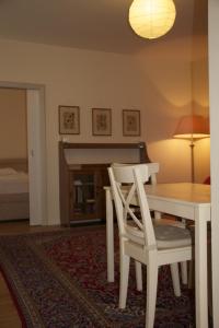 维也纳毕蔓仁塔尔公寓的一间带桌子和两把白色椅子的用餐室