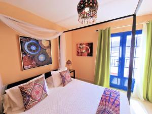 塞博河畔卡莱塔Suite Marrakech Beach, La Graciosa.的一间卧室配有一张床和一个吊灯