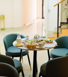 第比利斯Hotel DownTown Avlabari的一张桌子,上面有食物,上面有蓝色的椅子