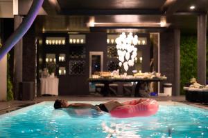 清迈Palm Villa - Award Winning Modern Luxury & Exclusive Villa Resort的躺在游泳池内管上的男人
