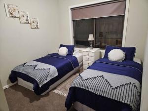 库克角Tranquil home in Point Cook.的一间卧室设有两张床和窗户。