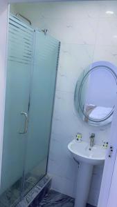 伊凯贾Thistle Greens Apartment的带淋浴、盥洗盆和镜子的浴室