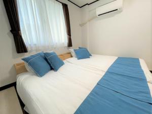石垣岛Portside美崎町 離島ターミナル徒歩3分 室内リニューアルOPEN的一间卧室配有一张带蓝色枕头的大床