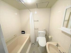 石垣岛Portside美崎町 離島ターミナル徒歩3分 室内リニューアルOPEN的白色的浴室设有浴缸、卫生间和水槽。