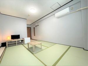 石垣岛Portside美崎町 離島ターミナル徒歩3分 室内リニューアルOPEN的一间空房间,配有桌子和白色的墙壁