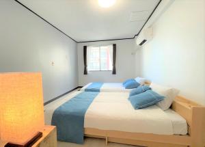 石垣岛Portside美崎町 離島ターミナル徒歩3分 室内リニューアルOPEN的一间卧室配有一张带蓝色枕头的大床