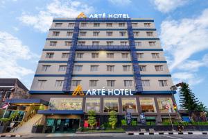 日惹Arte Hotel Yogyakarta的上面有标志的高大的白色酒店