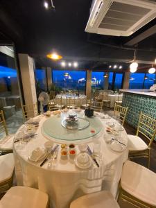 Phủ LýRiverside Hotel Hà Nam的用餐室配有带白色桌布的桌子