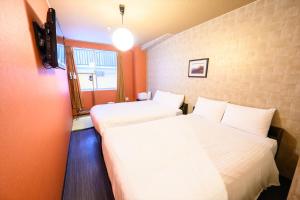 广岛Hiroshima Wabisabi hostel 広島ワビサビ ホステル的橙色墙壁客房的两张床