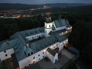凯尔采Karczówka Klasztor的享有大型白色建筑的顶部景色,设有绿色屋顶