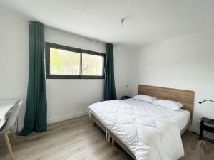拉罗谢尔Le Clos Guiton的一间卧室设有一张大床和一个窗户。