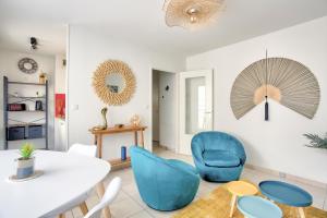 圣马洛Expédition Malouine - Appt à 30m de la plage的客厅配有白色桌子和蓝色椅子