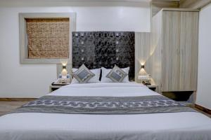 孟买Arts International的卧室配有一张白色大床和两盏灯。