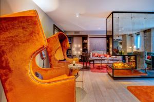 日内瓦f6风格酒店的客厅配有橙色椅子和沙发