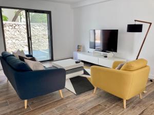 拉罗谢尔Le Clos Guiton的客厅配有两把椅子和电视