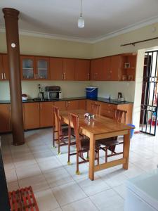 姆巴拉拉3-Bedroom Mbarara Apartment with Optional Farm Tour的厨房配有木桌和椅子