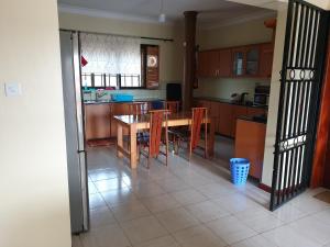 姆巴拉拉3-Bedroom Mbarara Apartment with Optional Farm Tour的厨房以及带桌椅的用餐室。