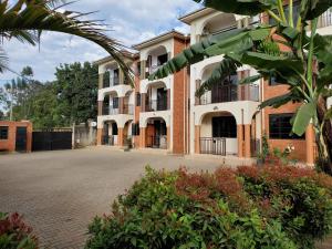 姆巴拉拉3-Bedroom Mbarara Apartment with Optional Farm Tour的一座大建筑,前面有一个庭院