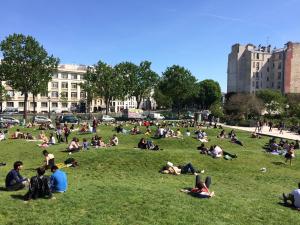 巴黎Studio Trip In Paris - Gare de l'Est的一群人坐在公园的草地上