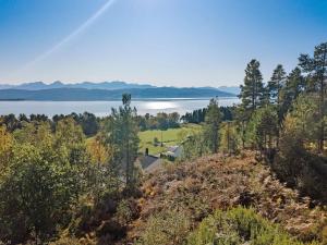 ÅrøyFeriehus nær badeplass og Molde sentrum的享有湖畔山丘上房屋的空中景致