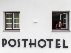 豪尔兹高Posthotel Lechtal的一位妇女从邮局的窗口看出来
