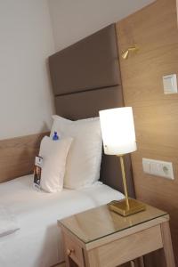 汉诺威弗伦霍夫贝斯特韦斯特酒店的一间卧室配有一张带台灯的桌子的床