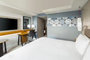 哈罗盖特哈罗盖特皇冠假日酒店 的酒店客房设有一张床、一张书桌和一台电视机。