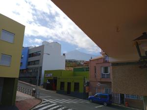 伊科德洛斯维诺斯Loft Estudio Habitación independiente的享有城市街道的景色,街道上设有建筑和一辆蓝色汽车