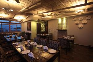 班加罗尔juSTa MG Road的一间在房间内配有长桌子和椅子的餐厅