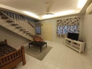 马六甲Juwita Homestay Bukit Katil - Free Unifi and 15 Minutes To Town的一间带楼梯和电视的客厅