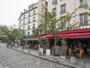 巴黎拉丁区 - 巴黎圣母院公寓的一条街上,有餐馆,有人坐在桌子旁