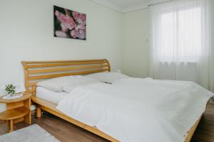 Schützen am GebirgeFerienwohnung Morgensonne的一间卧室配有一张带白色床单和一张桌子的床。