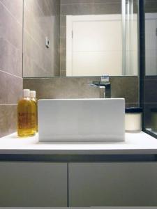 塔拉戈纳Stunning & Modern Penthouse - Rambla - City centre的浴室柜台配有水槽和1瓶肥皂