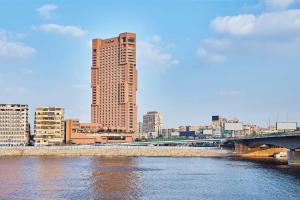 开罗拉姆西斯希尔顿酒店&赌场的一座高大的建筑,靠近一条有桥的河流
